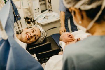 mother smiling looking at newborn child